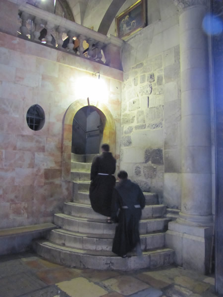 Priest ascending stairs to calvary in the Church of the Holy Sepulcher. 