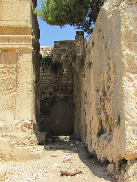 The tomb on the left is cut from the actual bedrock. The cube shaped tomb has had the rock cleared out around the sides and the back so that the actual tomb is still part of the original rock on the side of the Mount of Olives.