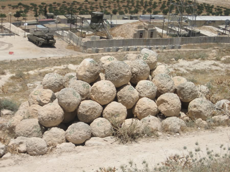 Round stone balls rolled down ramparts or rocks launched with catapults