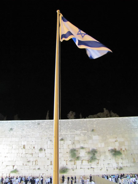 Israel flag flying in front of the Western Wall in Jerusalem 