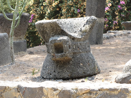 basalt stone hourglass shaped grain grinder that sat over a cone shaped basalt stone