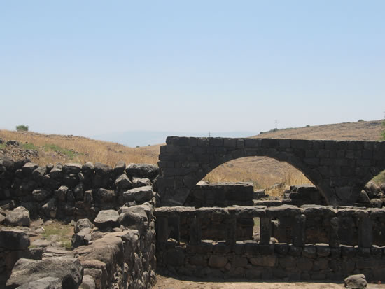 An interior wall with windows sets in front of a basalt arch.  The Sea of Gallilee is visible in the background when we where there on location.